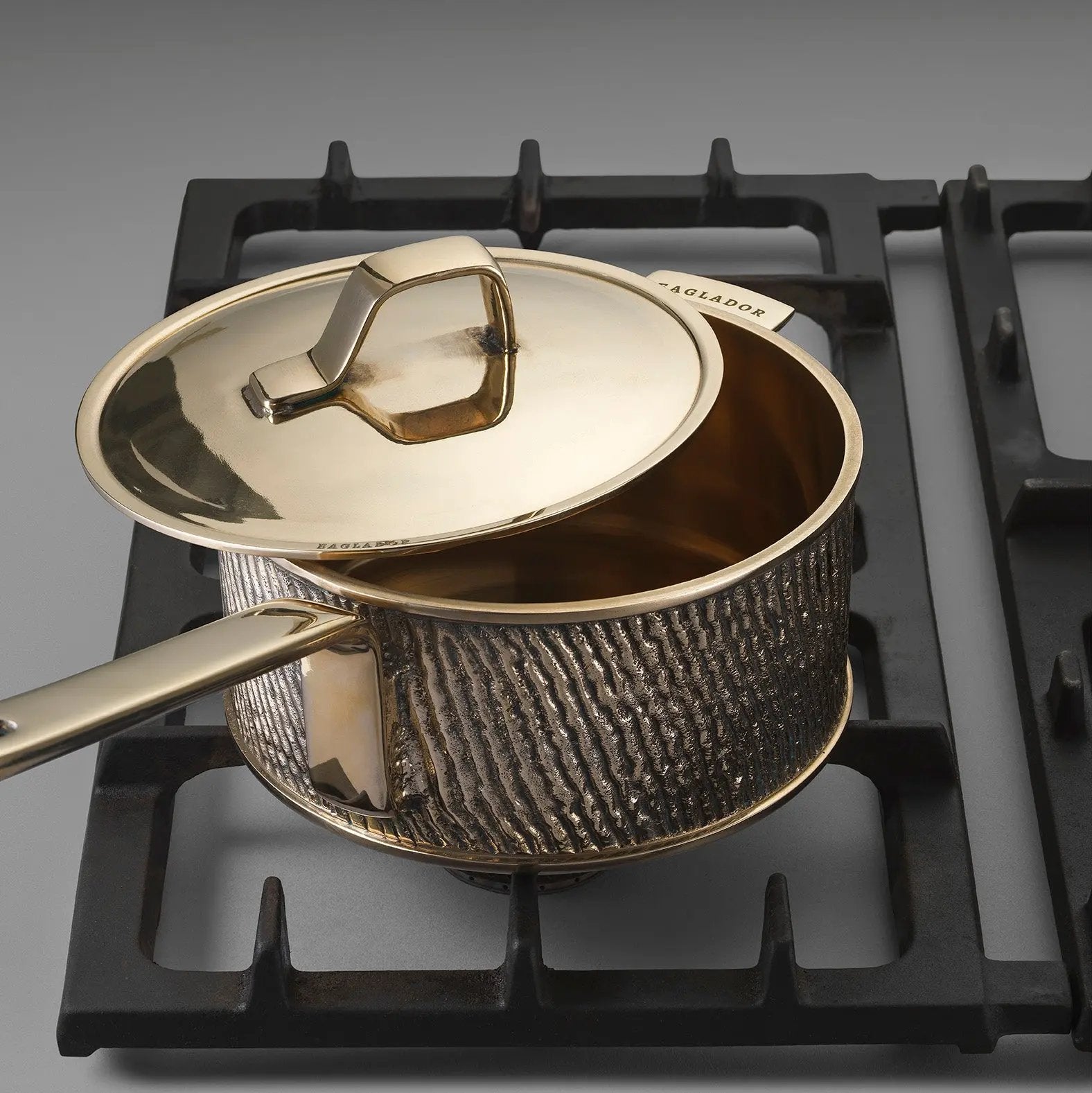 Luxurious bronze saucepan with a lid on a stove top
