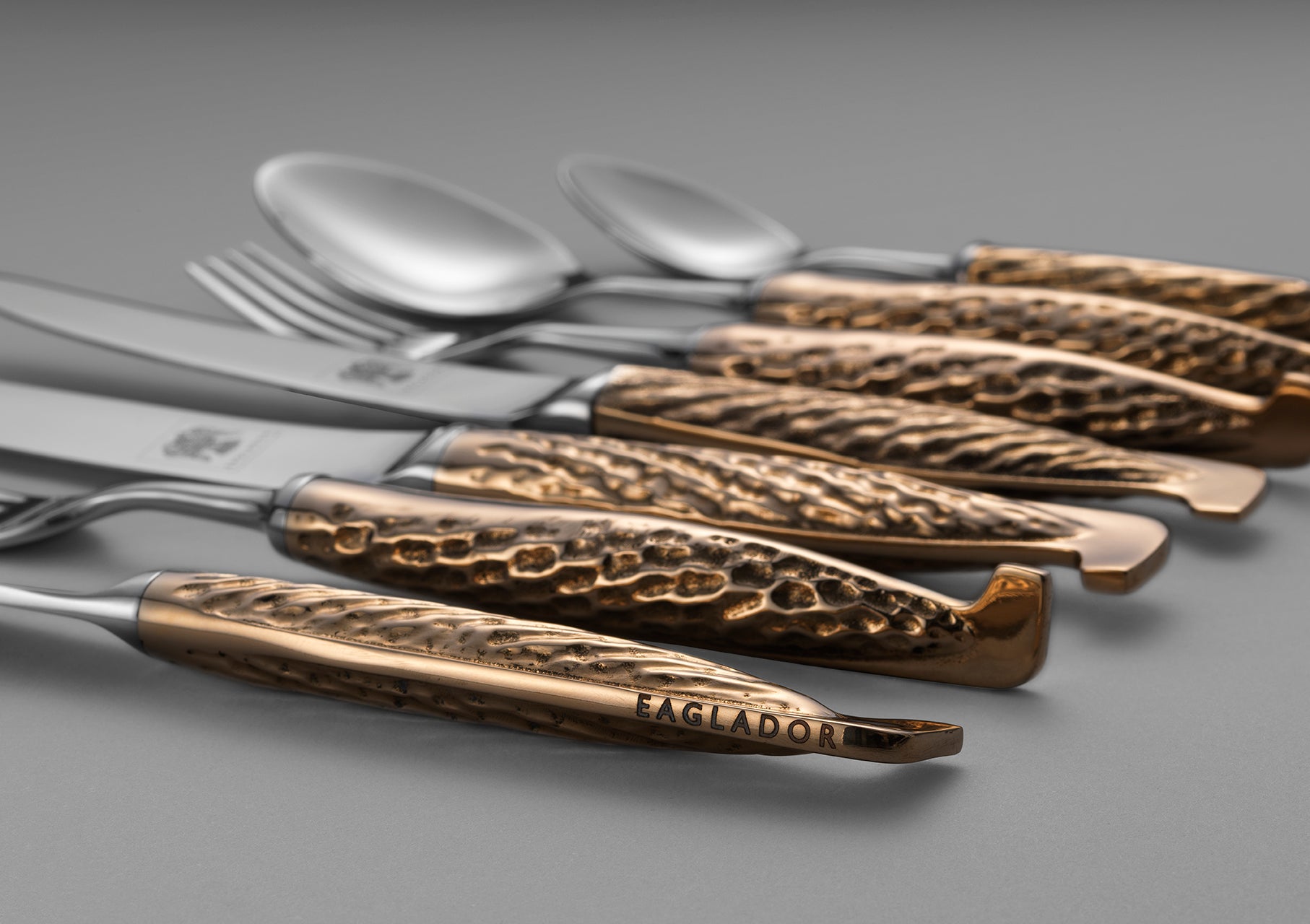 A collection of bronze handled flatware with sculptural detail by Eaglador