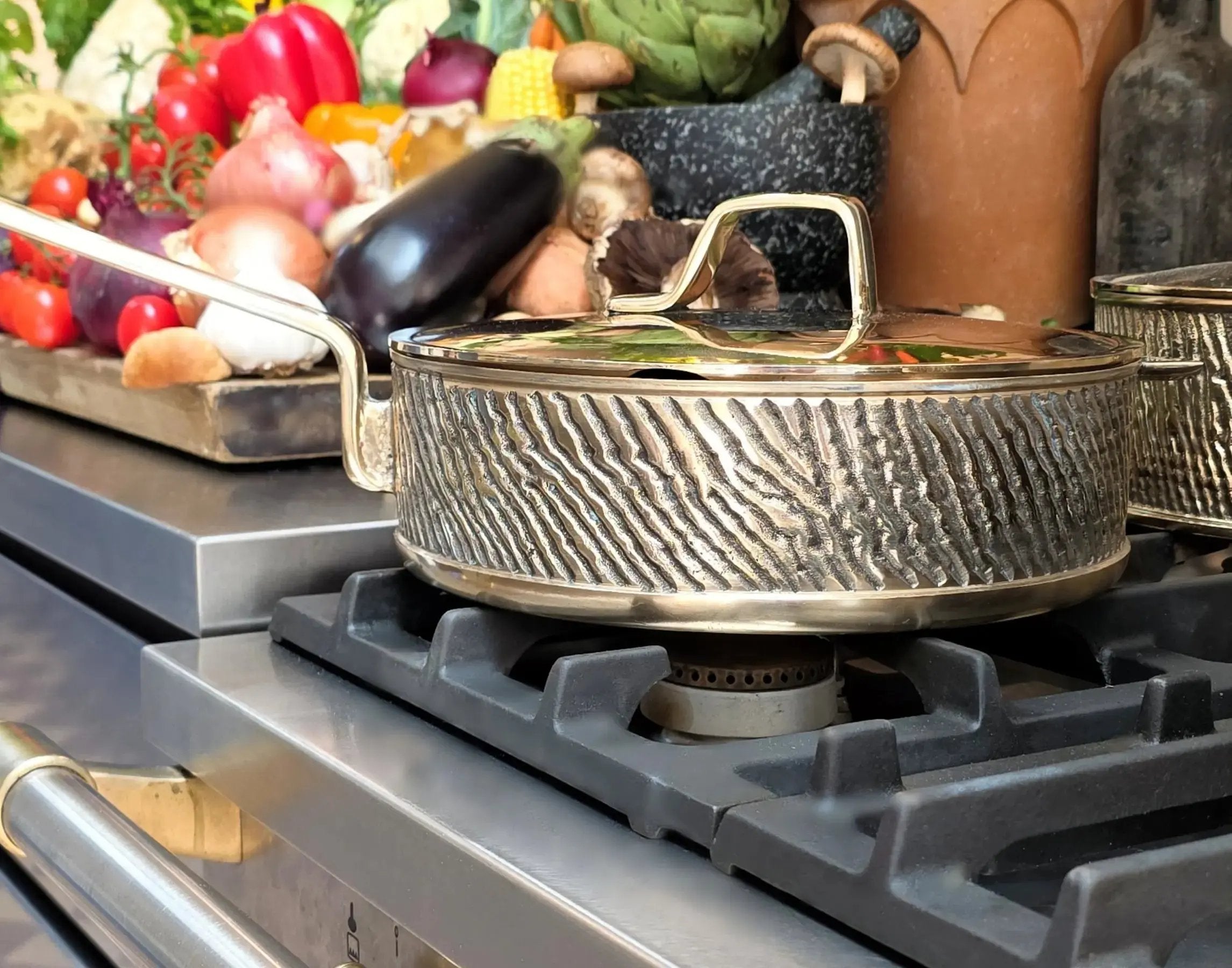 Handcrafted luxury Kansa bronze sauté pan Robustus on premium stovetop with fresh vegetables – Eaglador heirloom cookware