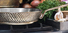 Handcrafted luxury Kansa bronze frying pan on premium stovetop with fresh ingredients – Eaglador heirloom cookware.